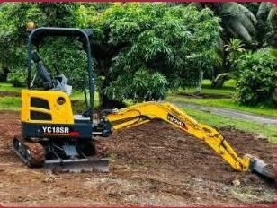 Mini-pelle Yuchai YC18SR en train de terrasser un jardin